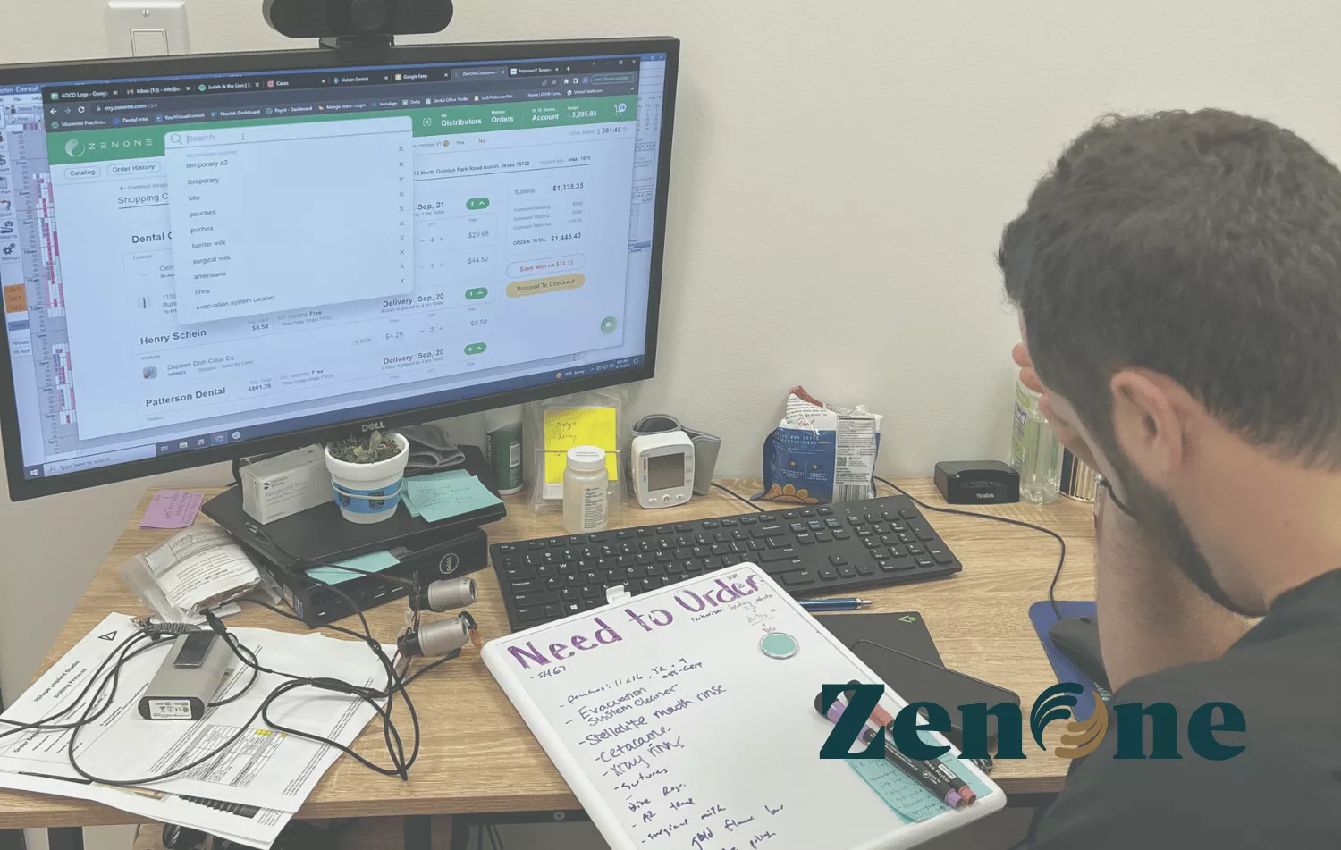 A dentists in his office viewing the ZenOne software on his computer.